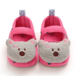 Detailed macro view of pink baby girl walking shoes with a plush cartoon bear face design