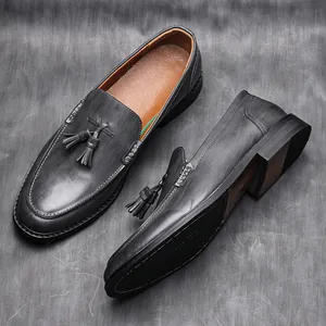 Elegant grey tassel loafers for men with wood grain sole detail for business attire.