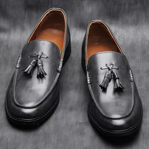 Close-up of premium burnished grey leather loafers featuring classic tassel detail and texture