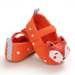 Detailed view of orange baby walking shoes with cute fox character and polka dots
