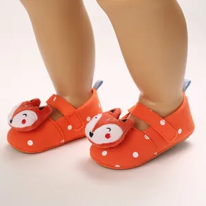 Close-up view of orange cartoon baby walker shoes with white polka dots and fox design