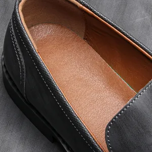 Close-up detail of the breathable leather insole and stitching inside a black loafer.