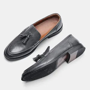 Detailed view of grey leather loafers showing tassel upper and textured non-slip sole
