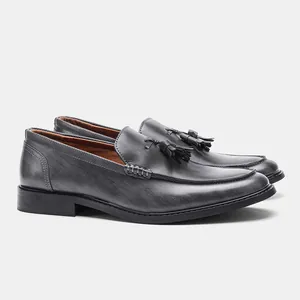 Detailed side view of men's grey wood grain leather loafers with tassels