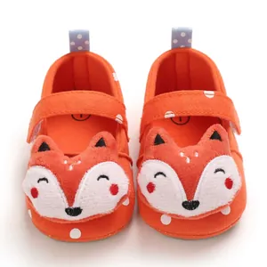 Orange baby walking shoes with cute plush cartoon fox head and white polka dots.