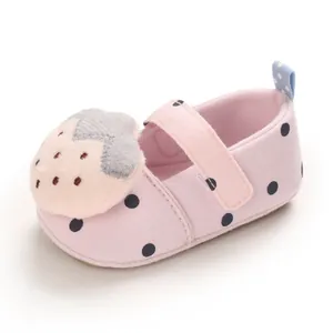 Pink baby girl walking shoes with blue polka dots and a cute plush strawberry detail.