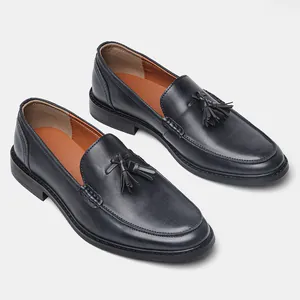 Detail shot of men's leather loafers featuring elegant wood grain texture and tassels