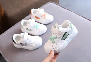 Close-up of kids' white shell-toe sneakers with soft soles and velcro straps