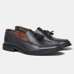 Detailed side view of elegant black leather tassel loafers for men business formal wear
