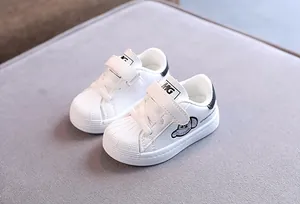 Classic white children's sneakers with shell-toe design, soft sole and adjustable strap