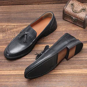 Detailed view of black leather tassel loafers with wood grain textured sole