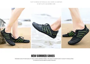 Atmungsaktive schwarz-grüne schnell trocknende Watschuhe in Strandumgebung fotografiert