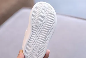 Close-up detail of durable anti-slip wavy pattern rubber sole for toddler white shoes