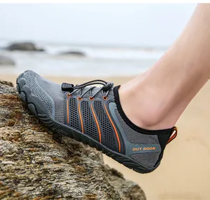 Detailansicht atmungsaktiver grauer Watschuhe mit orangen Streifen auf einem Felsen