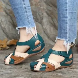 Detailed view of retro wedge sandals with cross straps and buckle in teal
