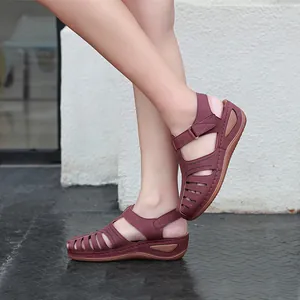 Detailaufnahme burgunderfarbener Damen-Keilsandalen mit Ausschnitten am Fuß