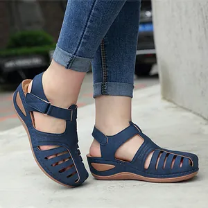 Nahaufnahme blauer Damen-Keilsandalen mit Lochmuster und rutschfester runder Kappe.