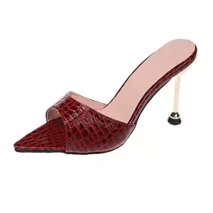 Détail d'élégantes sandales à talons hauts bordeaux avec motif crocodile et bout ouvert