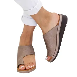 Sandalias de cuña taupe para mujer con diseño de bucle en punta sobre blanco