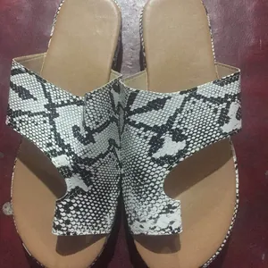 Vista detallada de sandalias planas para mujer con estampado de piel de serpiente en blanco y negro