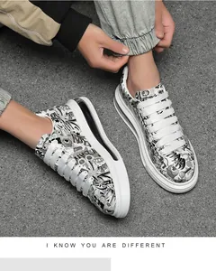 Close-up of men's graffiti print sneakers on a textured grey background