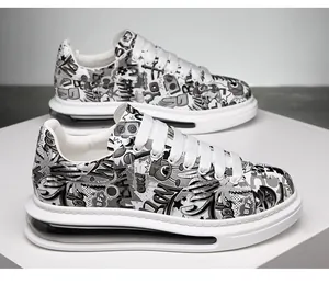 Close-up detail of men's trendy platform sneakers featuring bold black and white graffiti print