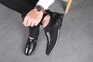 Λεπτομερής λήψη ανδρικών μαύρων loafers με ανάγλυφο σχέδιο φορεμένα σε μοντέλο.