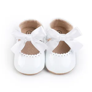 Elegante weiße Lackleder-Babyschuhe für Prinzessinnen mit großen Satinschleifen, Vorderansicht.