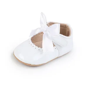 Detailansicht der weißen Lackleder-Babyschuhe mit großer Satinschleife