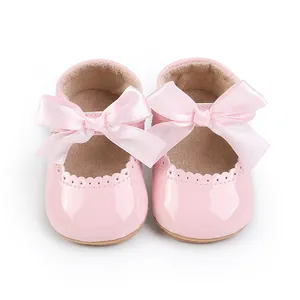 Detailansicht der rosa Baby-Prinzessin-Schuhe mit großer Satinschleife und Wellenrand.