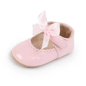 Detaillierte Nahaufnahme von rosa Lackleder-Babyschuhen für Mädchen mit Satinschleife