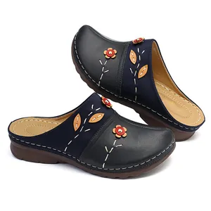 Elegant navy and black floral mules featuring decorative stitching and appliqués