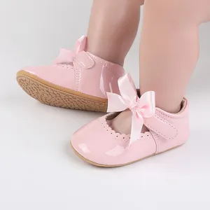 Detaillierte Nahaufnahme von rosa Lackleder Baby-Prinzessin-Schuhen mit Schleife.