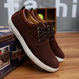 Detailed view of dark brown suede casual shoes with white sole and classic lacing.