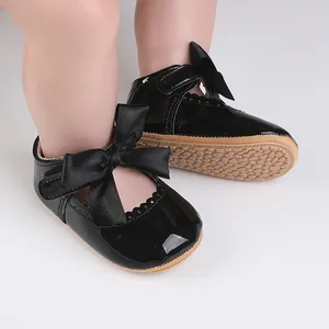 Detailansicht glänzend schwarzer Lacklederschuhe für Babys mit großer eleganter Schleife