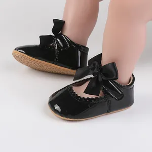 Detail von schwarzen Lackleder-Babyschuhen für Mädchen mit Schleife und weicher Sohle