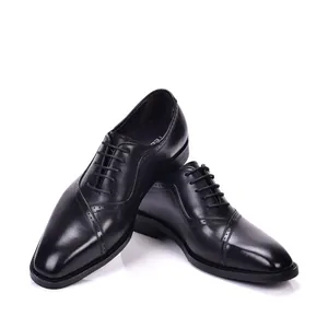 Detalle de zapatos Brogue de cuero negro para hombre en un estilo formal de negocios chic.