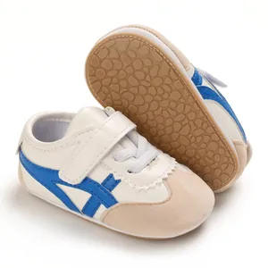 Detail view of white baby shoes with soft soles and blue stripe design for beginners