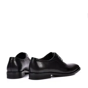 Vista detallada de los clásicos zapatos Brogue de cuero negro con elegantes perforados.