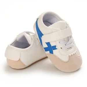 Side detail of baby white walking shoes with blue stripes and soft beige toe cap