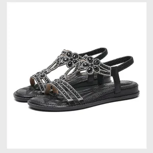 Detail view of Bohemian black flat sandals with sparkling rhinestone flower patterns