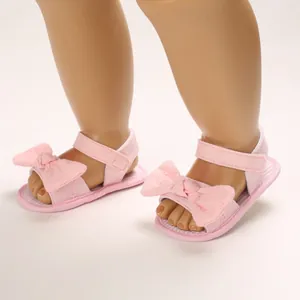 Vista dettagliata di sandali rosa per neonata con grandi fiocchi e suola morbida
