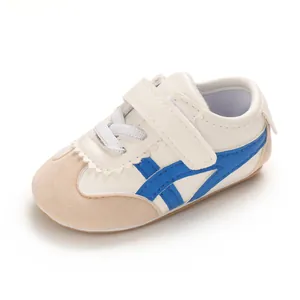 Soft-sole infant walking shoe in white and blue featuring a convenient velcro strap closure