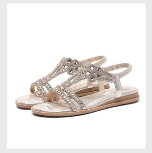 Close-up of sparkling rhinestone hollow-out design on champagne gold flat sandals