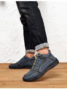 Side view of vintage blue leather casual shoes for men worn on a wooden floor background