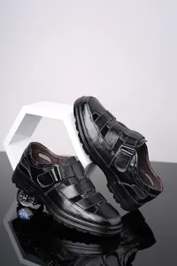 Vista detallada de sandalias de cuero negro para hombre con diseño calado transpirable y velcro