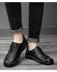 Dettaglio di mocassini casual da uomo in pelle nera con cuciture a mano decorative
