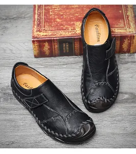 Dettaglio dei mocassini casual in pelle nera da uomo con cuciture decorative ai bordi.