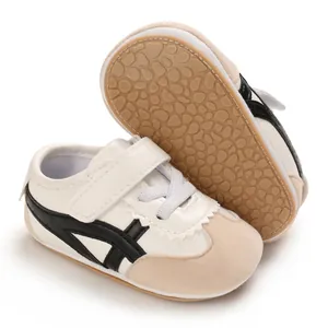 Close-up of white baby walking shoes with soft soles and anti-slip rubber grip.