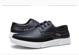 Macro view of navy blue men's casual leather sneakers featuring thick white soles.